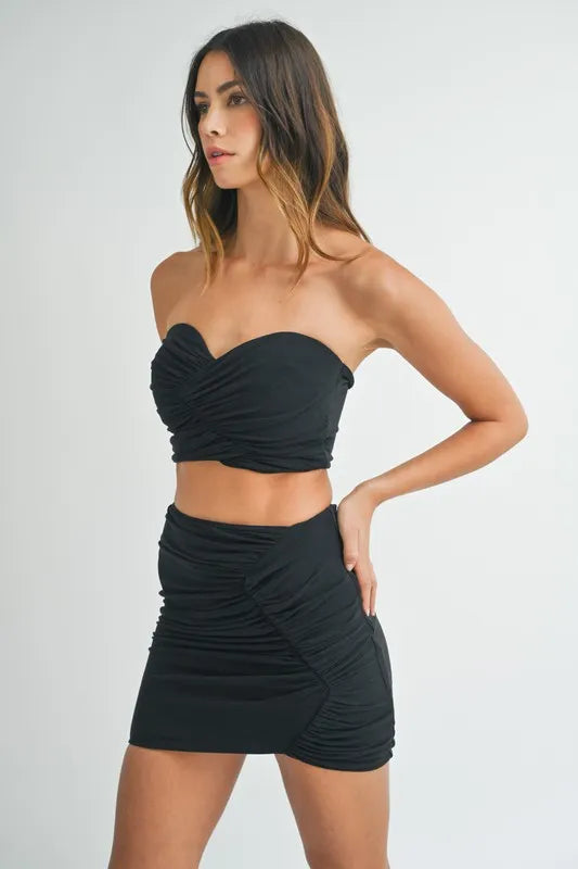 Side view of black two piece ruched mini skirt set

