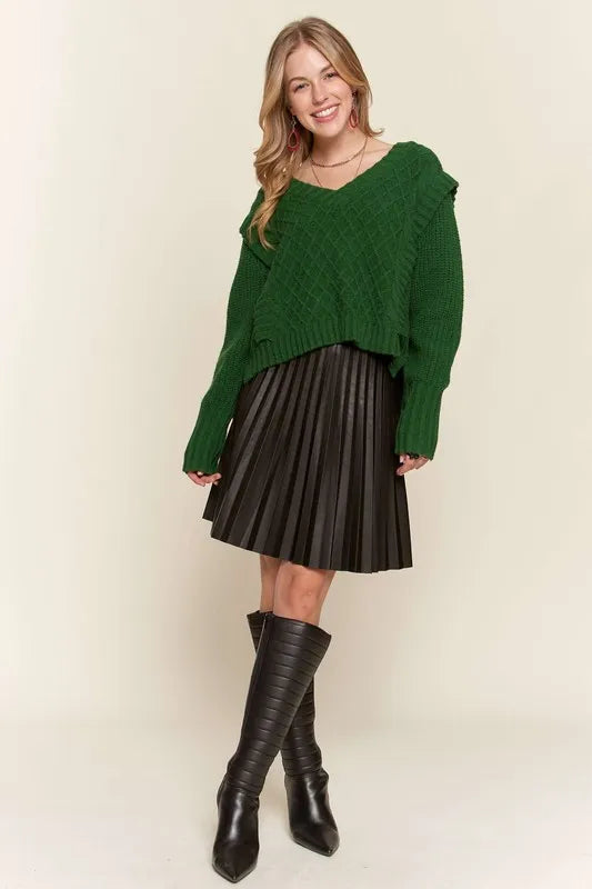 Full length view of Emerald Isle green cable knit sweater styled with a chocolate brown pleated mini skirt and tall boots.
