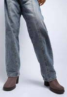 Blue jeans worn by a model on a white background