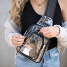 Close-up of clear sling bag featuring dual zippered compartments and adjustable strap
