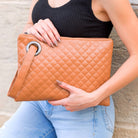 Cognac quilted clutch made with a premium soft quilted PU leather and cotton Herringbone print lining with grommet detail and wristlet.