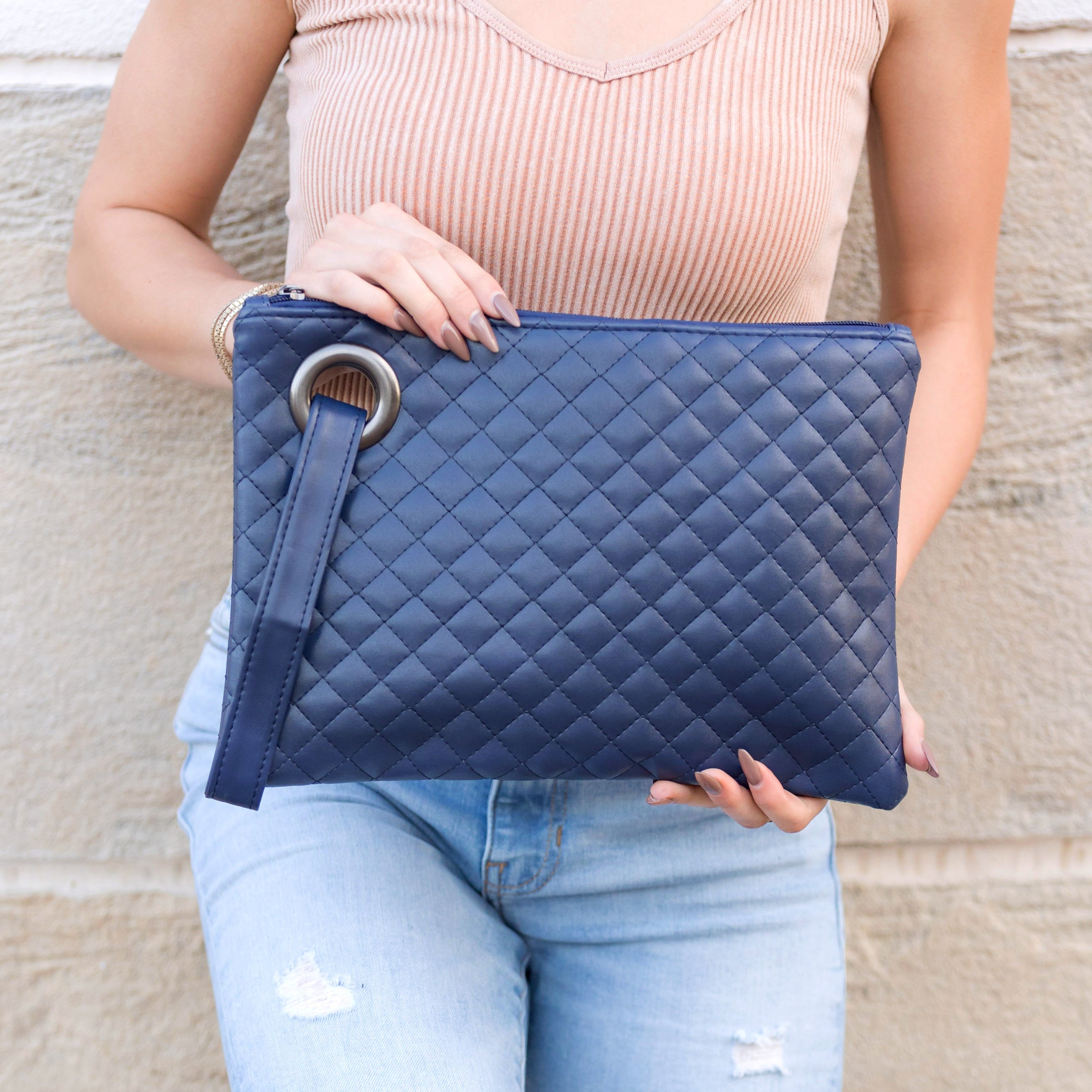 Navy quilted clutch made with a premium soft quilted PU leather and cotton Herringbone print lining with grommet detail and wristlet.