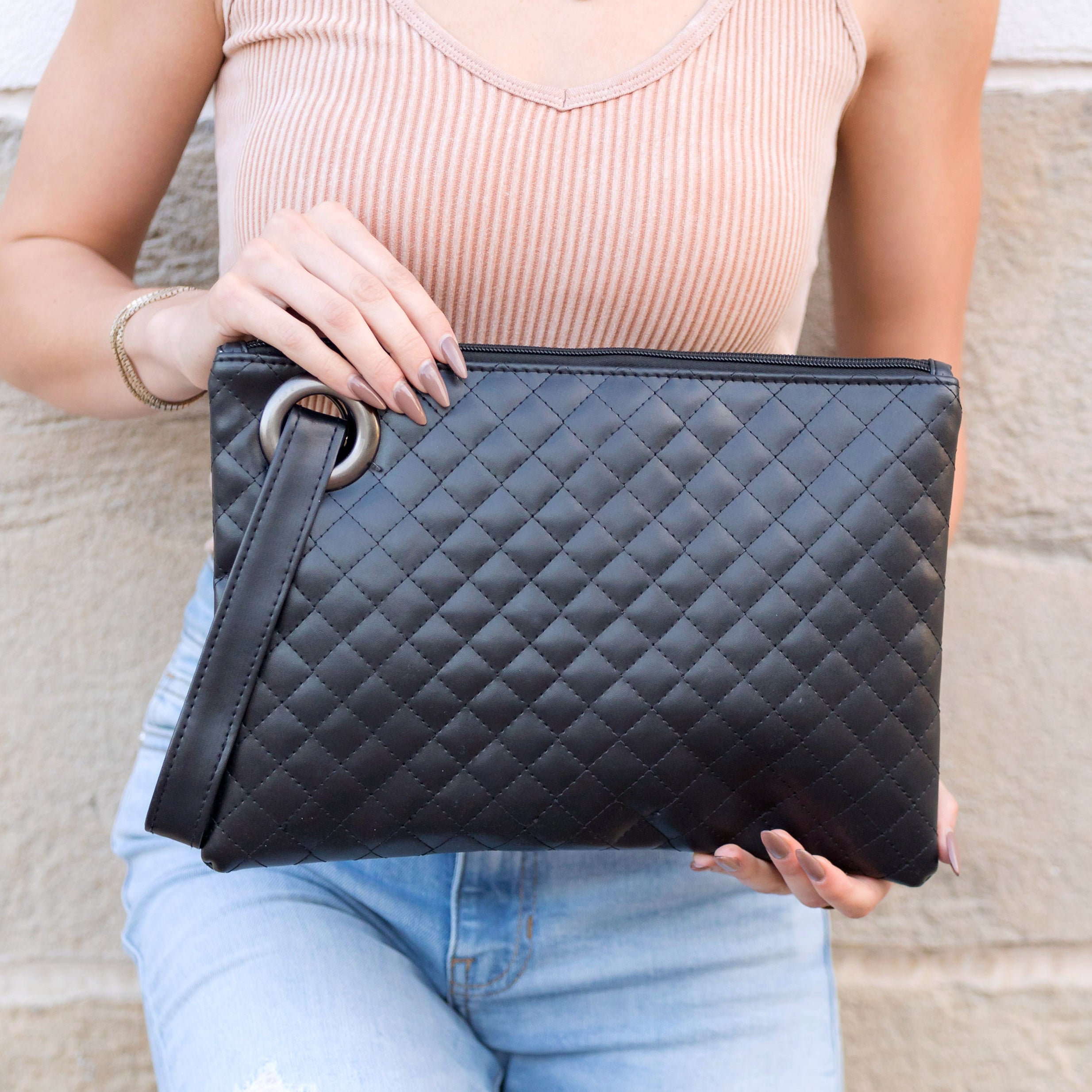 Black quilted clutch made with a premium soft quilted PU leather and cotton Herringbone print lining with grommet detail and wristlet.