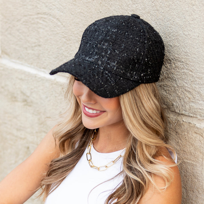 Woman wearing black tweed baseball cap with sequin detail

