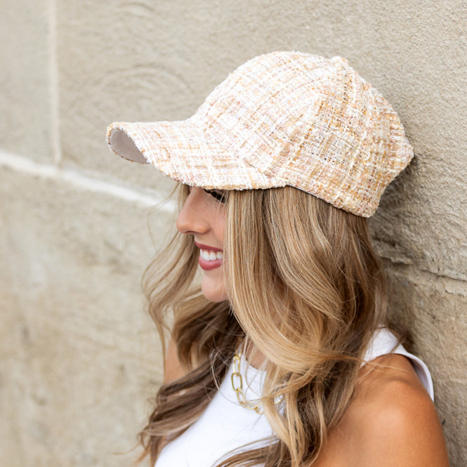 Woman wearing cream tweed baseball cap with subtle sequin detail

