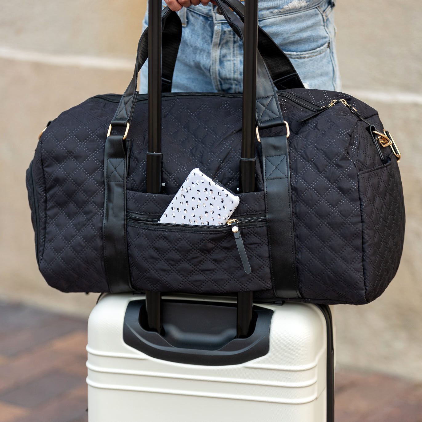 AVAH-Weekend Bliss Quilted Travel Bag in black featuring a timeless design with vegan leather accents, Exterior open side pocket, luggage/trolley sleeve, shoe compartment, zip pocket and gold hardware