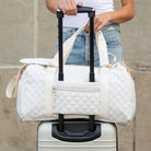 AVAH-Weekend Bliss Quilted Travel Bag in Bisque featuring a timeless design with vegan leather accents, Exterior open side pocket, luggage/trolley sleeve with zip pocket and gold hardware