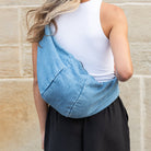 AVAH-soft denim crossbody bag featuring a relaxed crescent silhouette