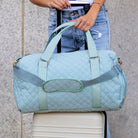 AVAH-Weekend Bliss Quilted Travel Bag in blue featuring a timeless design with vegan leather accents, Exterior open side pocket, luggage/trolley sleeve, shoe compartment, zip pocket and gold hardware