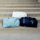 AVAH-Weekend Bliss Quilted Travel Bag in Bisque, blue and black: featuring a timeless design with vegan leather accents, Exterior open side pocket, luggage/trolley sleeve, shoe compartment, zip pocket and gold hardware