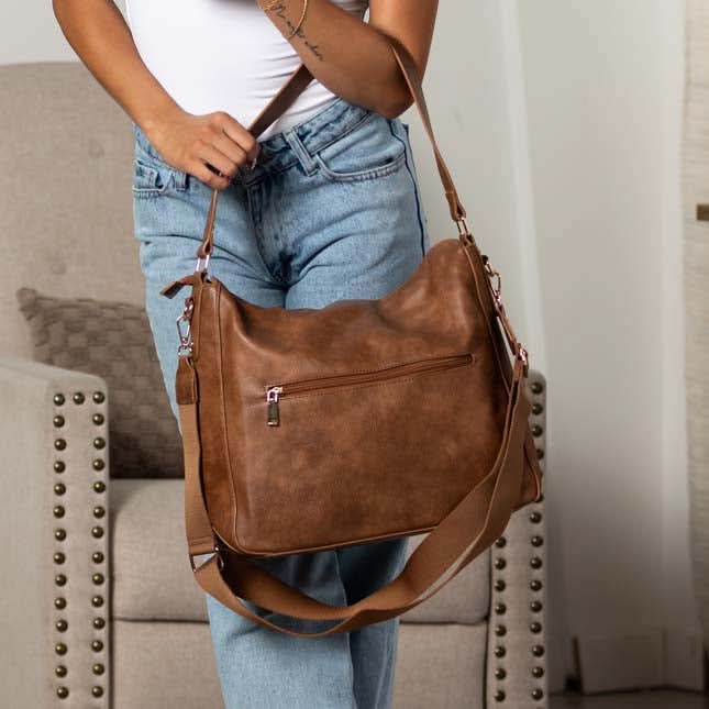 Rear view of cognac hobo bag showing exterior zip pocket.