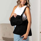 Black suede-look hobo shoulder bag and matching pouch worn indoors.