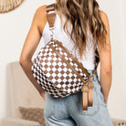 AVAH-Woman wearing a mocha and white checkered chic oversized sling bag with double zips and multiple pockets on a neutral background