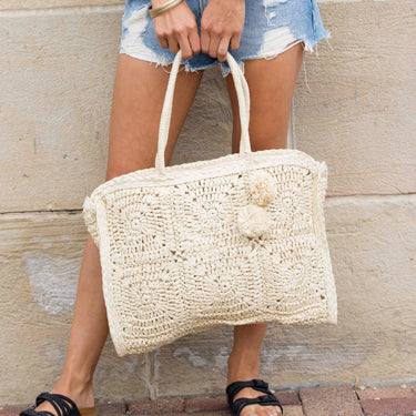 Nomadic Natura Straw Tote with artisan weave and pom-pom in straw front view
