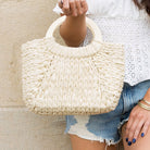 100% straw exterior tote bag lined with soft cotton with drawstring closure and wood handle in straw