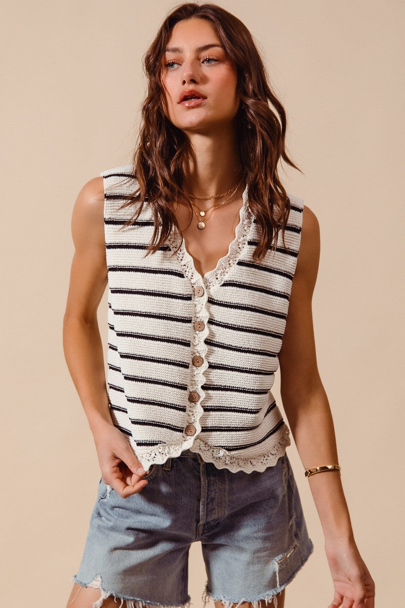 Woman wearing cream and black striped knit vest with crochet trim
