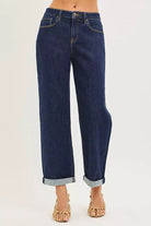 Dark indigo cuffed wide leg jeans showing cropped length and five pocket design

