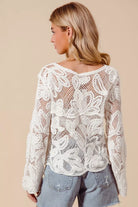Back view of ivory open knit lace cardigan with floral crochet detailing
