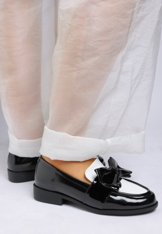 back view of black and white patent loafers with low heel
