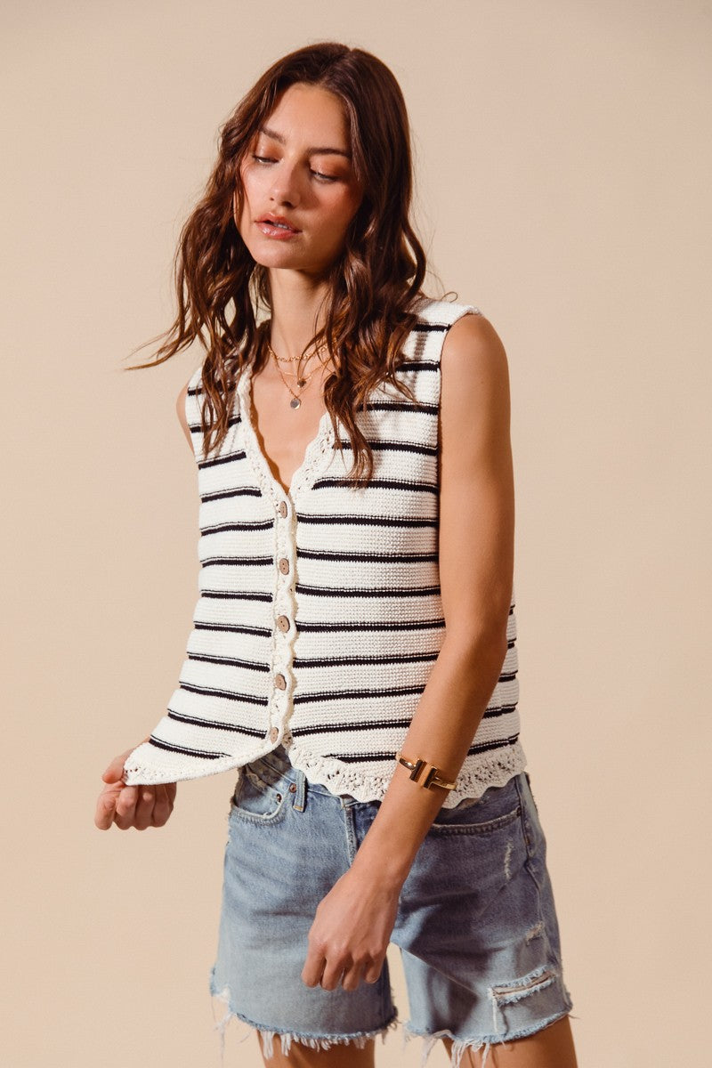 Woman wearing cream and black striped knit vest with crochet trim
