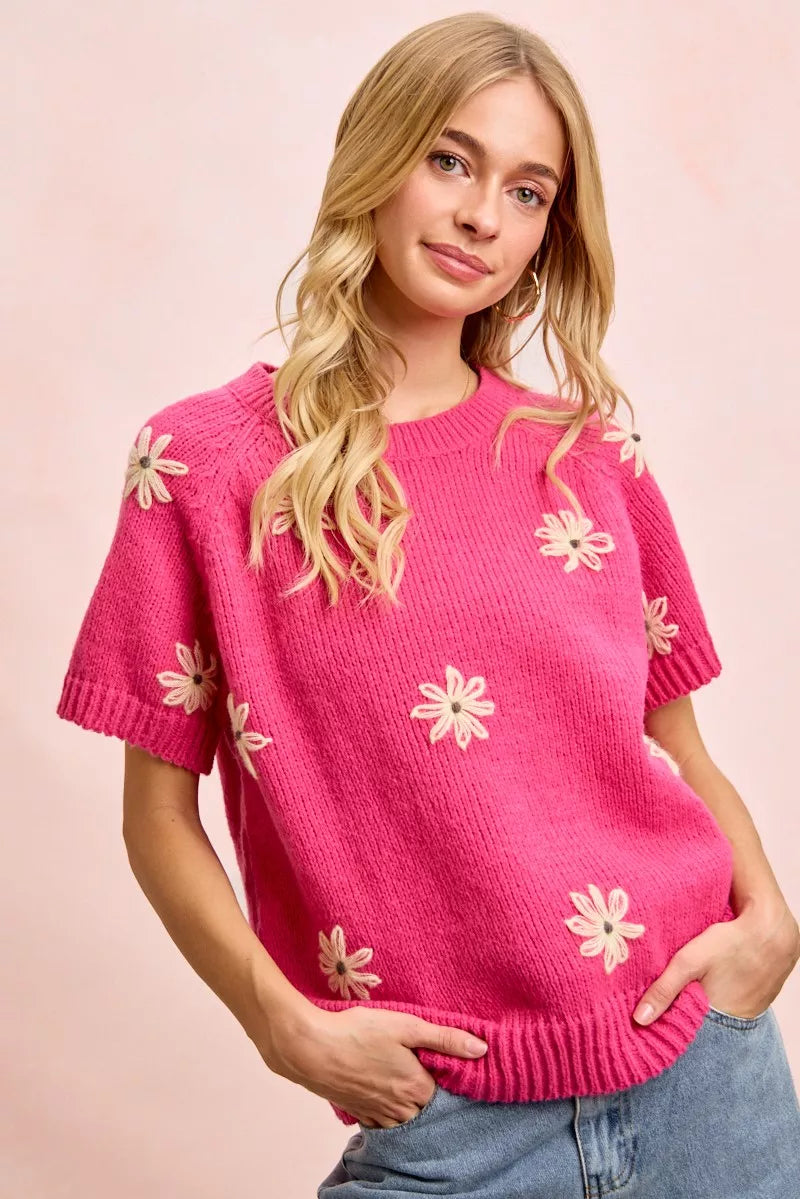 Pink daisy embroidered short sleeve sweater with crew neckline and ribbed trim
