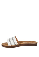 Side angle of white slide sandals with clean lines and slip-on functionality.