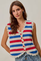 Woman wearing a red, ivory, and blue striped knit vest with scalloped trim and red buttons
