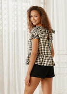 Back view of gingham top showing tie-back bow and peplum hem
