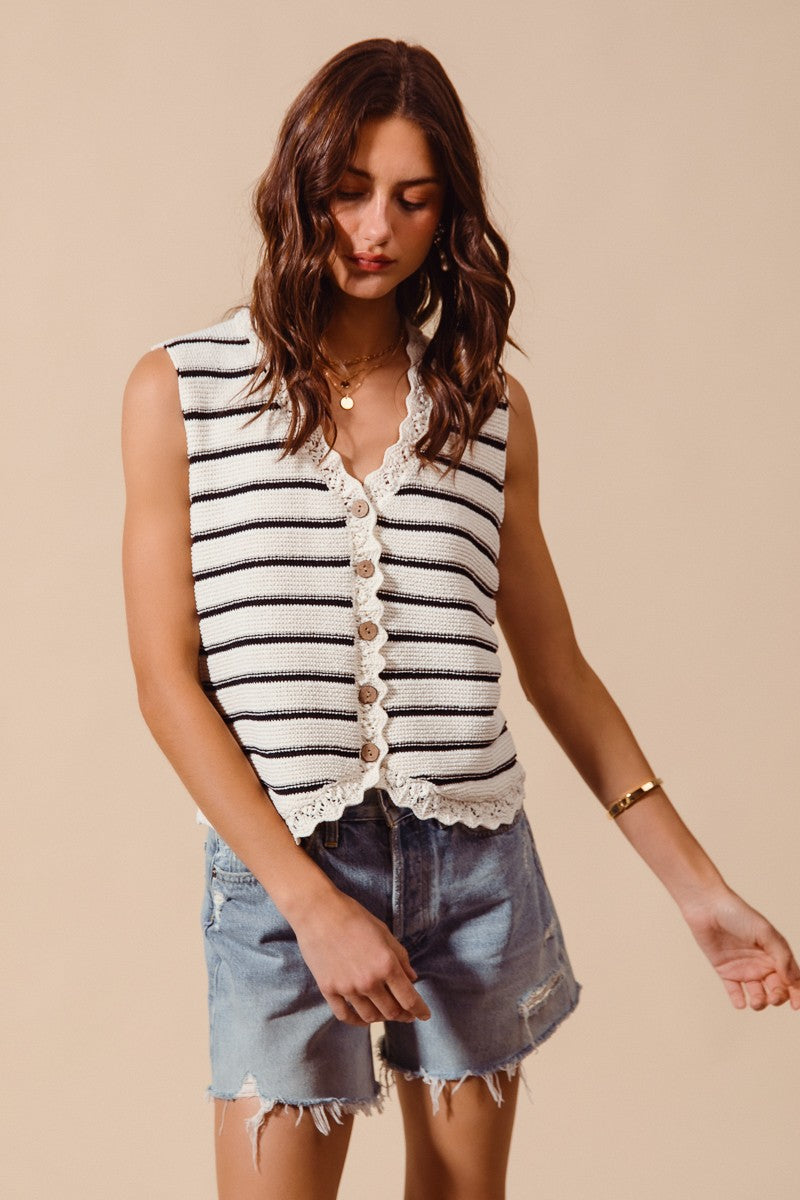 Woman wearing cream and black striped knit vest with crochet trim
