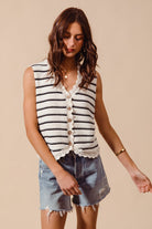 Woman wearing cream and black striped knit vest with crochet trim
