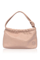 Beige leather handbag with a knot detail on handle on a white background