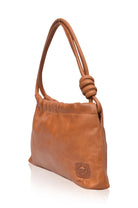 Tan leather handbag with a knot detail on a white background, 3/4 view