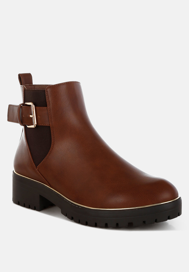 Brown leather ankle boot with a buckle on a white background