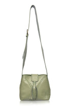 olive green leather handbag with fringe details and wide crossbody strap on a white background, front view