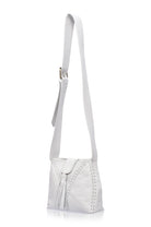 A white leather shoulder bag with a long strap, featuring a front flap with a tassel detail and decorative perforated stitching, shown against a plain white background.