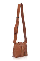 Camel leather handbag with fringe details and wide crossbody strap on a white background, 3/4 view