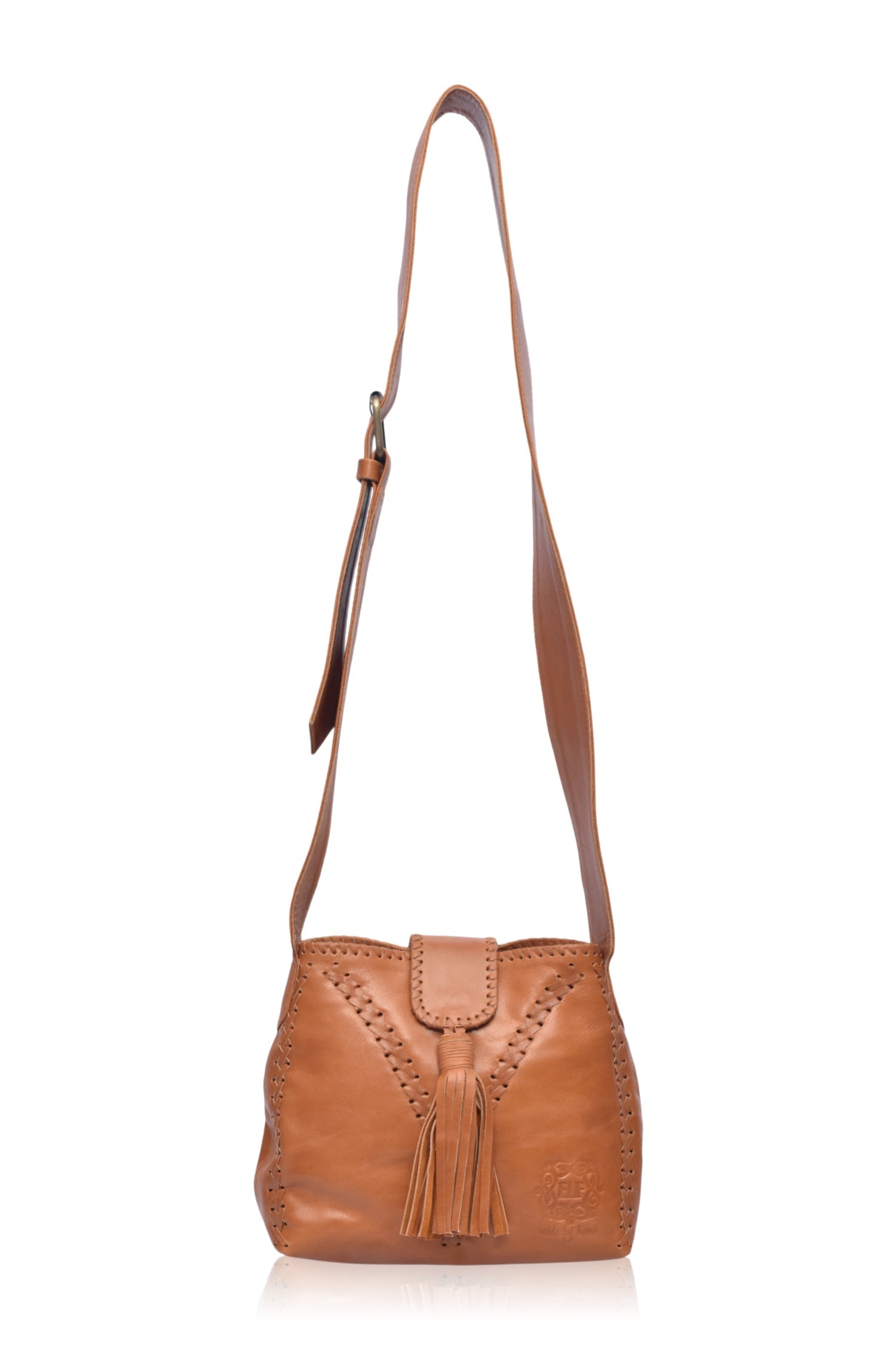 A tan leather handbag with fringe details and wide crossbody strap, on a white background, front view
