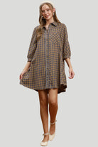 Full length front view of brown and grey plaid mini shirt dress with relaxed silhouette and button front.
