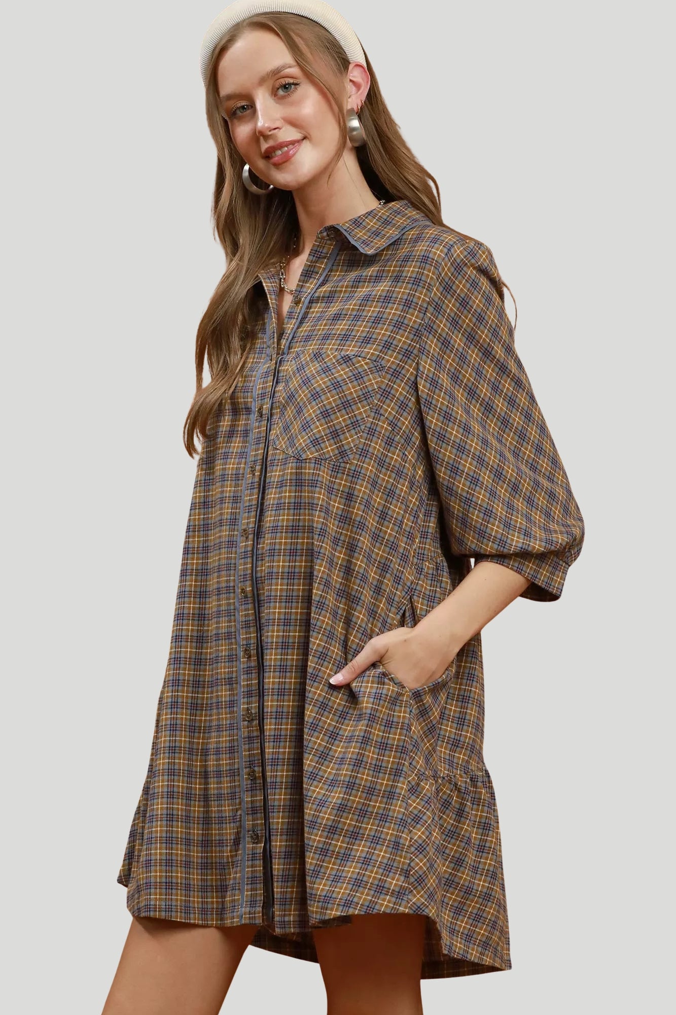 Brown and grey plaid shirt dress with collared neckline, chest pocket, contrast piping and side patch pocket.
