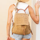 AVAH-Back view of woman wearing khaki woven crochet backpack with brown leather straps