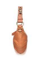 Tan leather bag with strap with hardware on a white background, side view