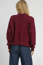 Back view of Bordeaux burgundy cable knit cardigan showing textured knit, long sleeves and ribbed hem.