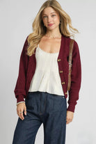 Bordeaux burgundy cable knit cardigan with V neckline, tortoise style buttons and relaxed fit, front view.
