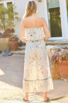 Back view of sage strapless boho jumpsuit with elastic waist and tiered hem
