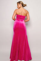 Back view of a fuchsia strapless maxi dress with fitted silhouette and floor length hem.