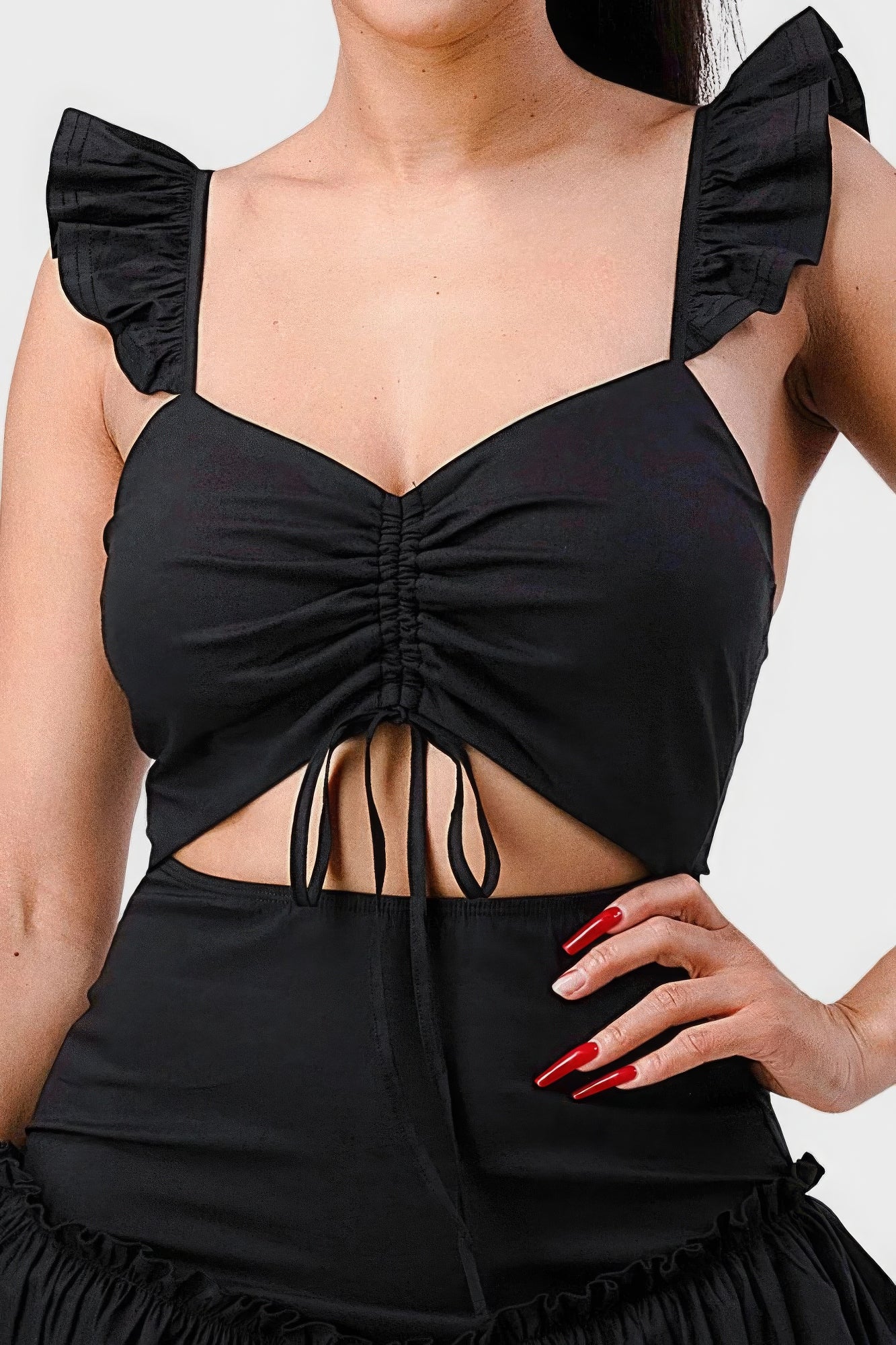 Close-up of ruched sweetheart neckline with flutter straps on black mini dress
