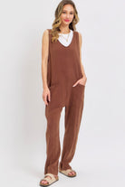 Woman wearing mocha brown cotton gauze jumpsuit with oversized front pockets
