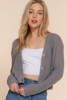 Model wearing gray cropped cardigan open over a white crop top, showing versatile styling-AVAH