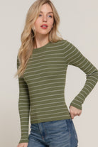 Model posing in an olive striped ribbed knit top and blue jeans, showing the fitted silhouette from mid-thigh up.