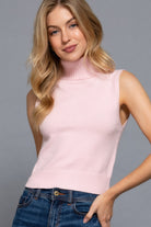 Woman wearing blush pink sleeveless knit turtleneck top, front view-AVAH